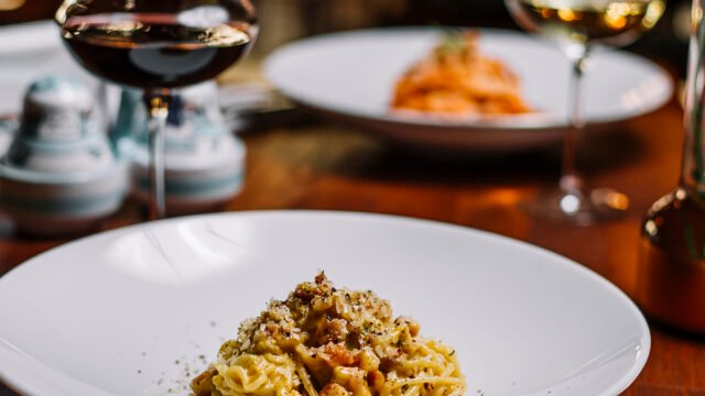 spaghetti with meat in creamy sauce garnished with grated parmesan